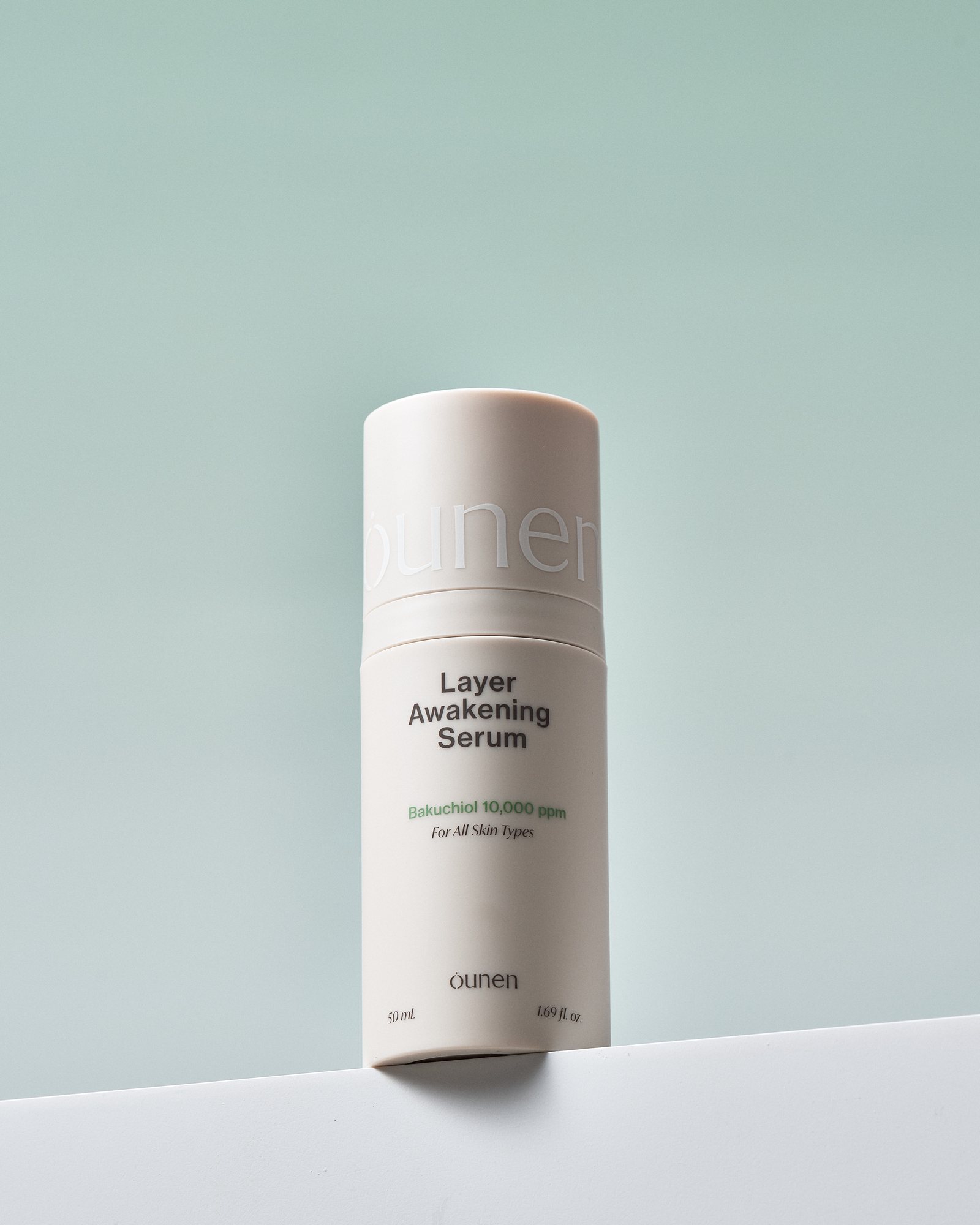세이지 톤 배경 위에 놓인 Layer Awakening Serum